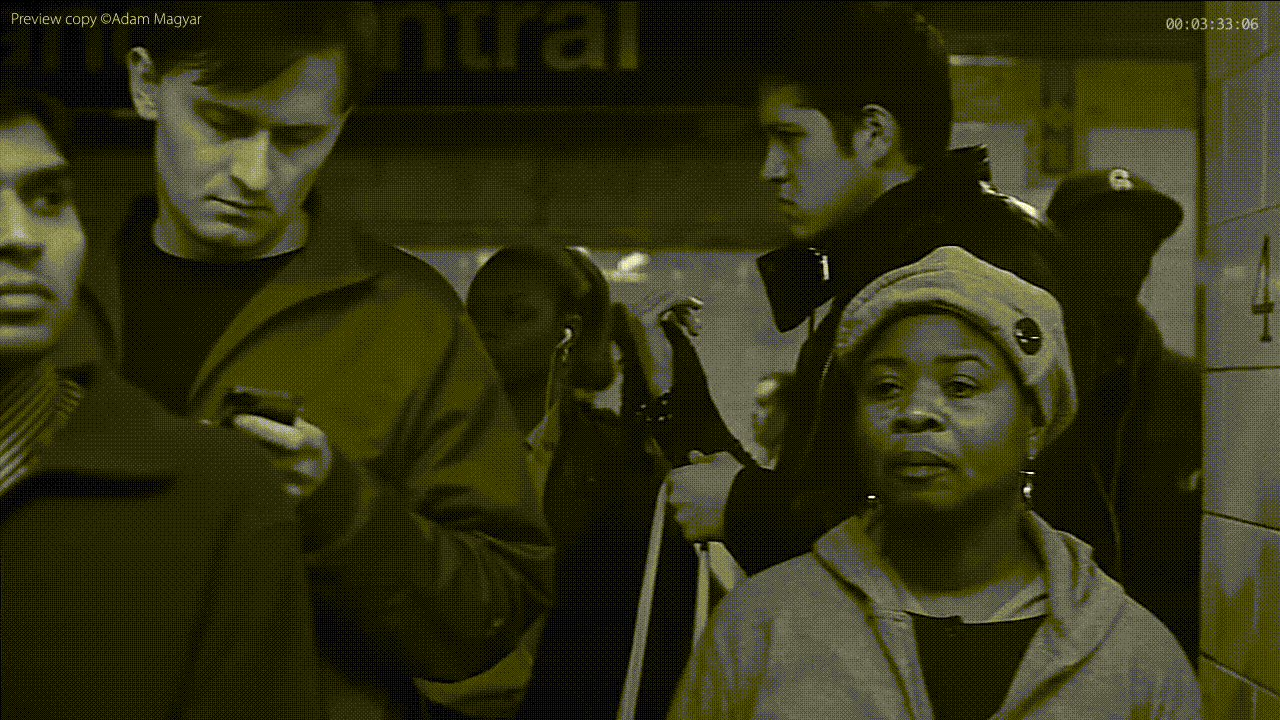 Une séquence montre un groupe de personnes dans une gare. Les personnes sont immobiles, comme si le temps s'était arrêté.