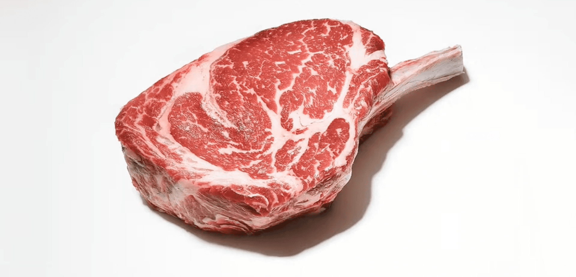 La photo montre un morceau de viande rouge, qui ressemble à un faux-filet ou à un filet avec un bon persillage.